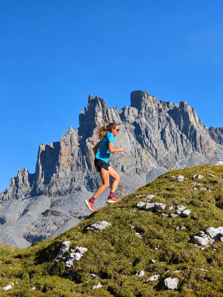 Walenstock-Loop – Community Run & Trail Challenge | Sonntag Trailrunnerin auf einem alpinen Bergweg vor markanten Felsgipfeln bei Engelberg