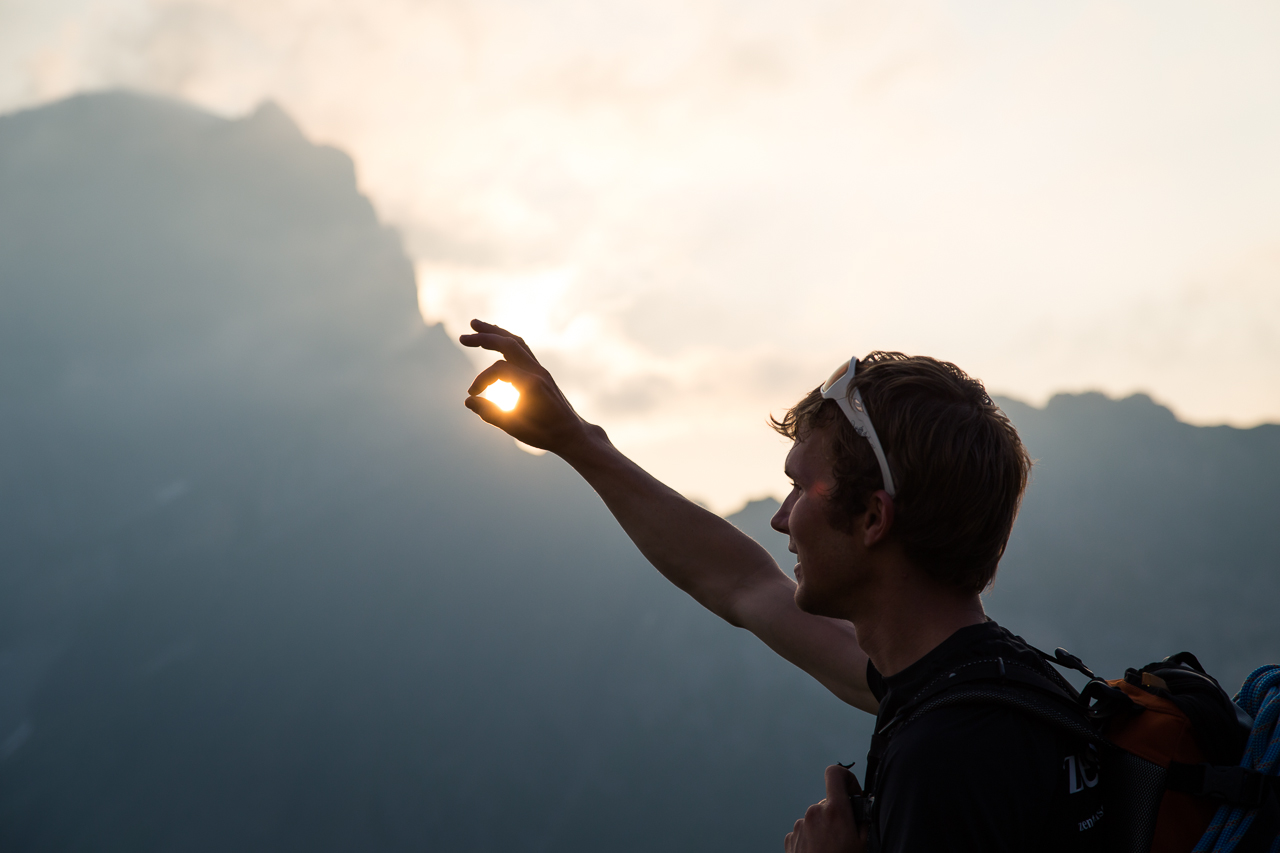 Bergwanderer zeigt im Abendlicht in die Berglandschaft bei Engelberg