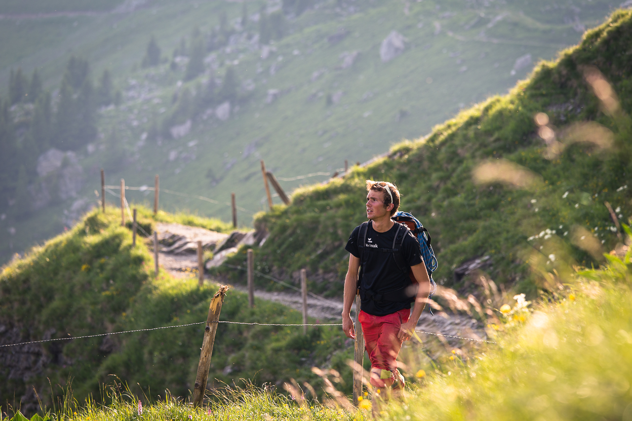 Wanderer auf einem Bergweg durch grüne Hänge bei Engelberg